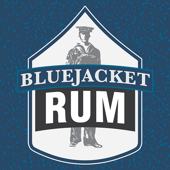 front label of the blue jacket rum with world war one US Navy sailor standing behind name on chevron shape frame, dedicated to the US Navy